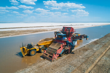 Heavy machinery works along the banks of Baskunchak Lake, actively extracting salt and transporting...