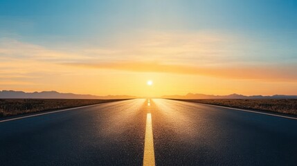 Long road leading to glowing horizon at sunrise.