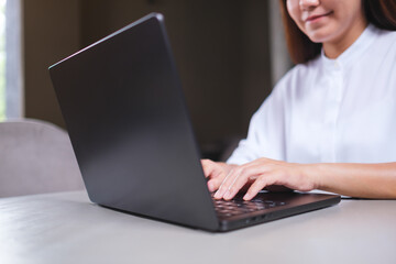 Closeup image of a woman working and typing on laptop computer keyboard