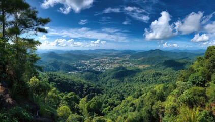 Panoramic mountain vista, lush green forests, and a valley town nestled below
