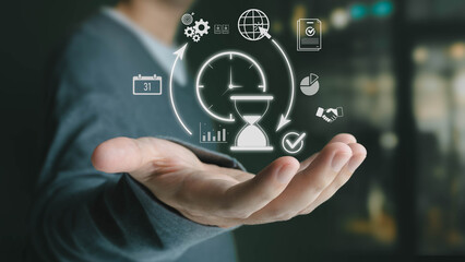 A businessman in a suit holds out his hand, displaying a glowing hologram of time management and productivity icons, symbolizing efficient project planning and workflow optimization in a modern office