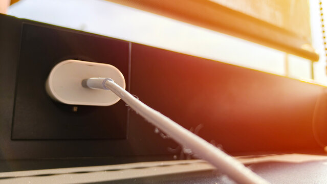 Mobile phone charger plugged into the outlet