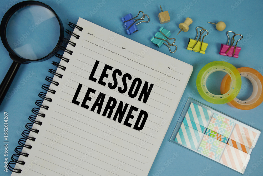 Aufkleber lesson learned text with magnifying glass on blue background