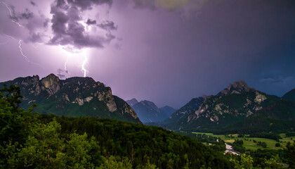 Lightning strikes over a mountain range during a thunderstorm.