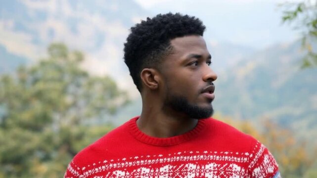video of a black man wearing a red christmas knitted sweater in slow motion he is looking arround