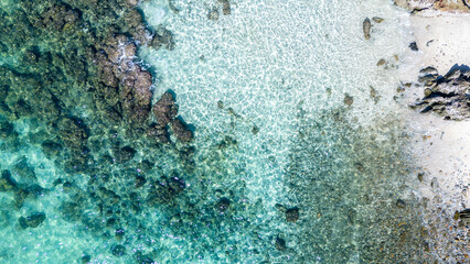 Aerial top view of crystal-clear turquoise sea water with visible underwater texture. Ideal for backgrounds, travel promotions, and marine environment concepts.