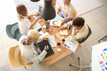 Team of graphic designers working at table in office