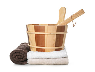 Wooden bucket with ladle and clean towels for sauna on white background © Pixel-Shot