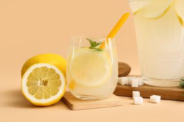 Glass of fresh lemonade with mint and sugar on beige background