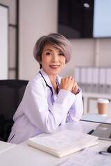 Asian adult female doctor smiles professional medical expert modern office clinic healthcare...