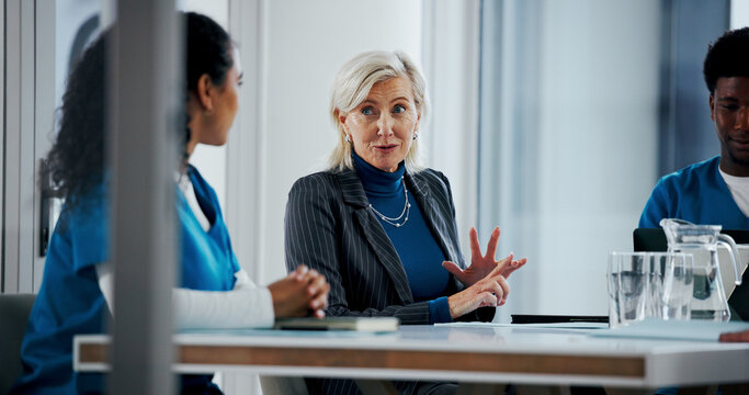 Doctors, discussion and business woman in meeting for hospital manager, surgery schedule and healthcare. Medical, planning and nurses with mature person in boardroom for clinic report and team - Powered by Adobe