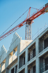 Construction site showcasing progress on a multi-story building under a clear blue sky