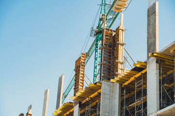 Construction site showcasing progress on a multi-story building under a clear blue sky