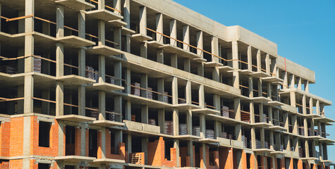 Construction site showcasing progress on a multi-story building under a clear blue sky