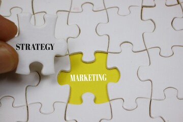 Puzzle Concept Depicting Strategy Marketing with Highlighted yellow Piece	