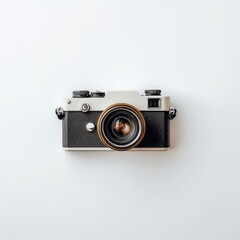 Fototapeta premium Vintage camera, top-down view, on a plain white background. A black and cream-colored 35mm film camera sits centered on a plain white surface. The camera's lens is visible, 