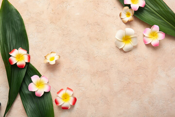 Beautiful plumeria flowers with tropical leaves on beige background