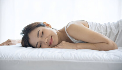 Fototapeta premium Woman peacefully dozing off on a mattress, side sleeping position, bright clean background.