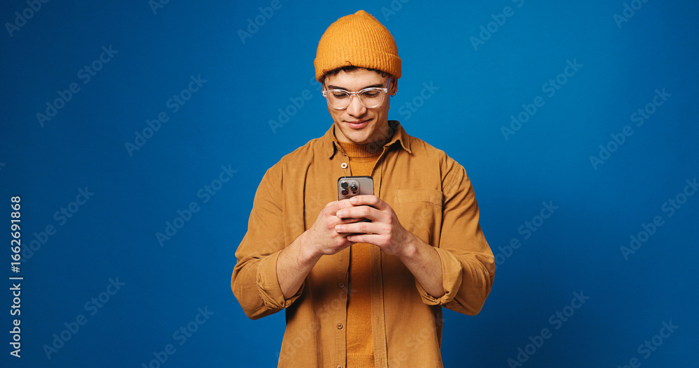 Wall mural phone, glasses and scroll with man in studio for social media, networking and connection. mockup spa