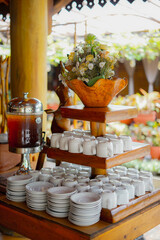 Outdoor Beverage Station with Wooden Stand and Floral Arrangement
