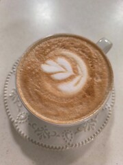 Latte Art Coffee on White Table, a Delightful Morning Treat with Floral Design, Top View
