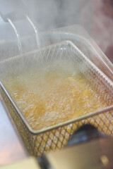 Frying chips in hot oil at a busy kitchen