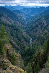 Fototapeta premium Mountain valley with river, forest, and cliffs