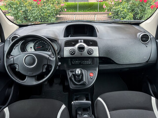 A captivating modern car interior view highlighting a sleek steering wheel and an elegant gear...