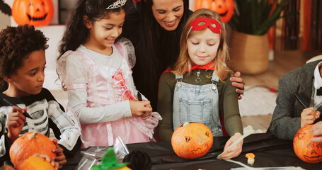 Halloween, kids and drawing on pumpkin with mother for hug, smile or learning in home. Vegetable...