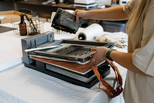 Manual Silk Screen Printing on Fabric – Close-up of Hands Working with Screen Printing Machine in Workshop