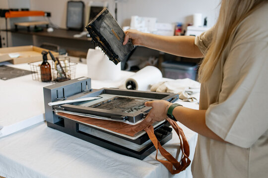 Manual Silk Screen Printing on Fabric &ndash; Close-up of Hands Working with Screen Printing Machine in Workshop