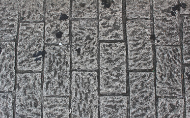 Texture of gray square paving tile. Pattern of sidewalk tiles in the street. Concrete pavers close...