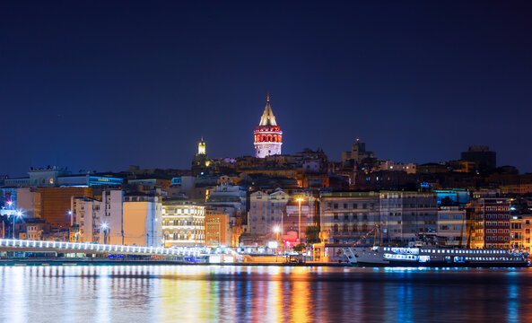 Fototapeta Galata Tower, Galata Bridge, Karakoy district and Golden Horn with motion speed light of passing ferry in the foreground at night istanbul - Turkey  
