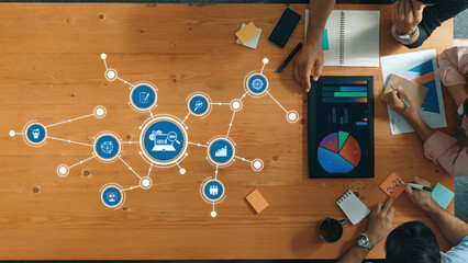 Collaborative Analysis and Planning Session with Business Metrics and Visual Data Representations on a Wooden Table. Amity