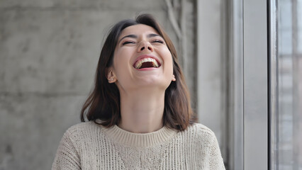 Beautiful woman deeply immersed in a fit of pure laughter, expressing immense happiness and an uplifting mood.
