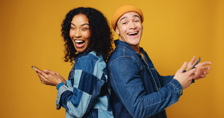 Portrait, funny and people in studio, smartphone and laughing on yellow background. Happy friends,...