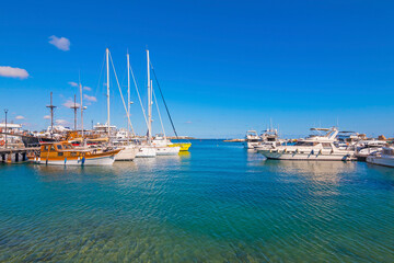 The marina in Paphos, Cyprus, shines under the bright Mediterranean sun — a picturesque spot with docked boats, seaside cafés, and palm-lined promenades, perfect for a relaxing coastal stroll.
