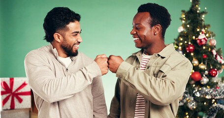 Christmas, fist bump and friends in studio for celebration, support and holiday season. Happiness,...