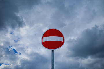 No entry road sign against cloudy sky