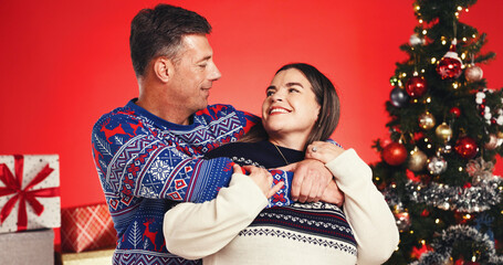 Christmas, hug and smile with couple in studio together for bonding and gift or present. Happy,...