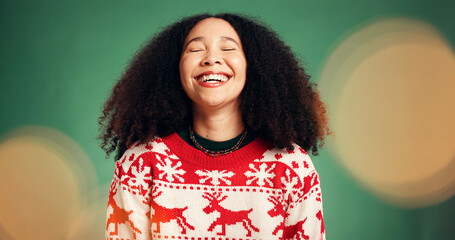 Smile, woman and laughing in studio for Christmas season, celebration and festive tradition. Happy, African person and bokeh with xmas jersey, funny joke and december holiday on green background