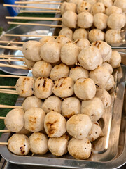 Grilled meatball skewers stacked on metal trays ready to serve with savory and appetizing look