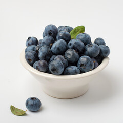 Fresh blueberries in a bowl on a light background. Healthy nutrition, vitamins