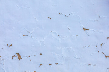 White wall of a vintage building with peeling paint
