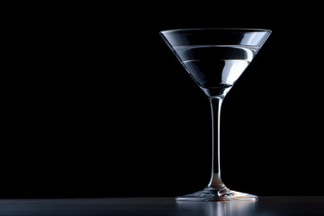 Cocktail glass on reflective surface with dark background