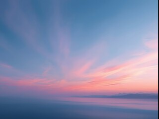 Colorful serene sunset sky over calm water horizon with dreamy pastel clouds in soft pink and blue tones, creating tranquil abstract nature background and peaceful atmosphere