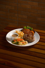 Grilled Pork Steak with Fries and Vegetables. Juicy pork loin served with crispy french fries, steamed mixed veggies, and a savory sauce. Classic Western cuisine.