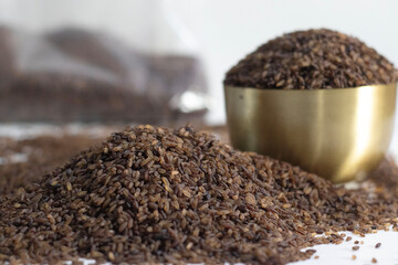 Niranam black rice in brass bowl with brown grains, symbolizing Kerala culinary heritage and pride