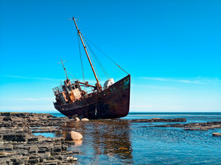 old wrecked sunken ship on the rocky shore of the Arctic Ocean is the