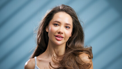 Beautiful young woman with long flowing hair, showcasing radiant skin and a natural glow, posing...